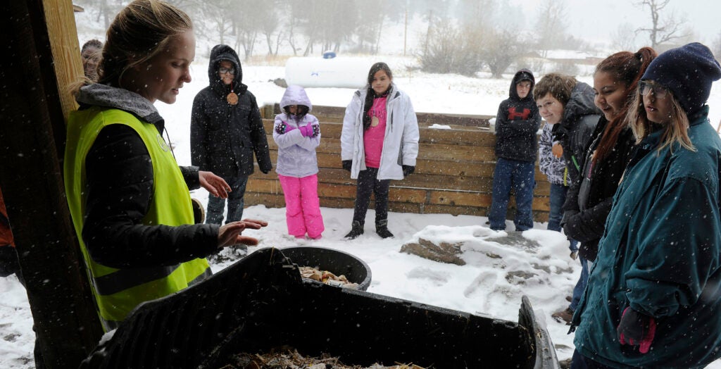 Students stand outside in a snowy environment.