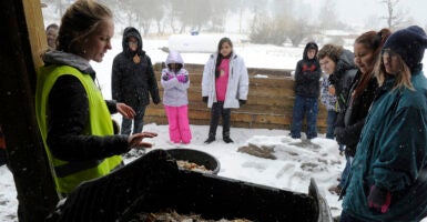 Students stand outside in a snowy environment.