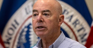 Mayorkas speaks during a press conference in a light blue button down shirt.