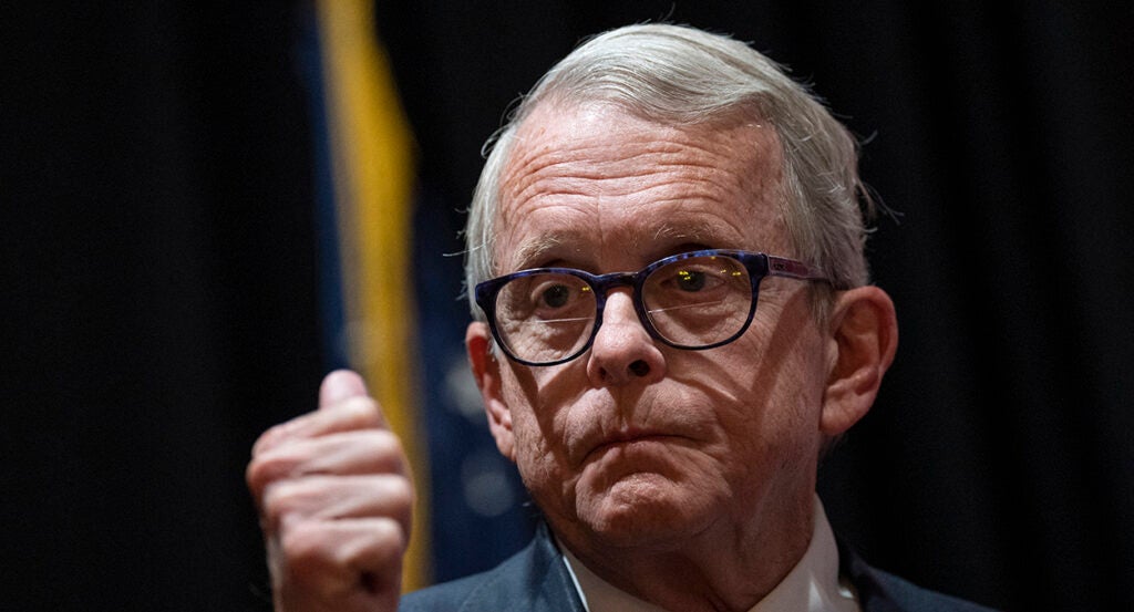 Ohio Gov. Mike DeWine purses his lips in a suit while wearing glasses