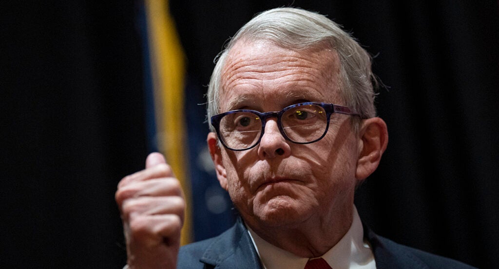 Ohio Gov. Mike DeWine makes a thumbs up gesture in a suit