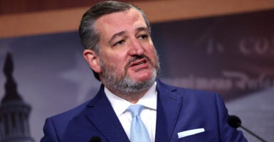 Ted Cruz speaks in a blue suit with a blue tie and wearing a salt-and-pepper beard