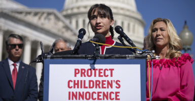 Detransitioner Chloe Cole stands in front of the Capitol behind a sign reading, "Protect Children's Innocence."