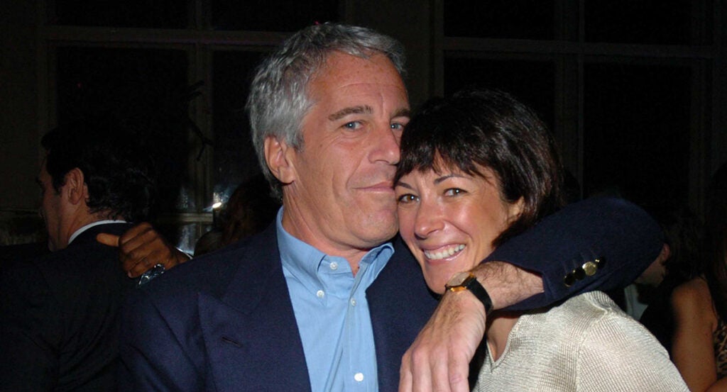 Jeffrey Epstein in a blue suit coat hugs Ghislaine Maxwell