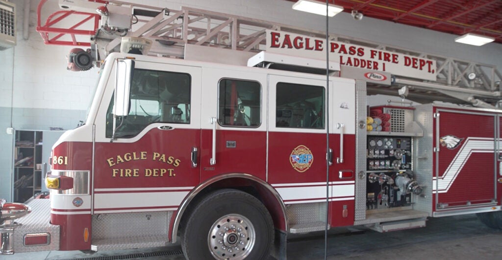 A firetrucks sits in a fire house.