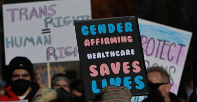 Protesters march with signs reading 