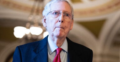 Minority Leader Mitch McConnell looks ahead in a dark blue suit and red tie.