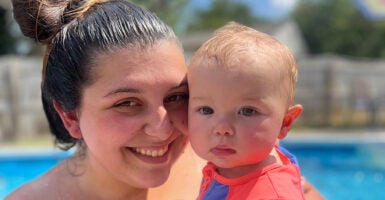 Katelynn Perry holds her baby girl in a swimming pool and smiles.