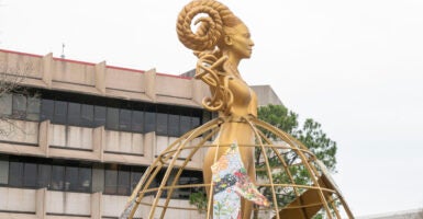 A golden, female-looking statue with braided horns overlooks the University of Houston campus.