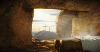 Three crosses on Golgatha and an empty tomb with a shroud and a rock pulled across the tomb entrance