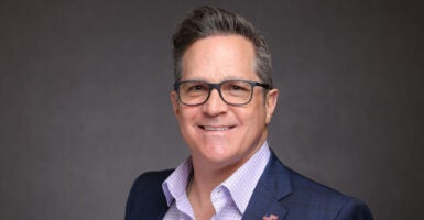 Russ Salerno in a blue suit and glasses wearing an American flag pin