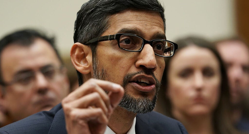 Google CEO Sundar Pichai in a suit with a salt-and-pepper beard speaks