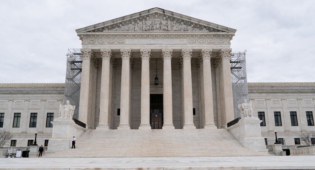 The Supreme Court building in the U.S. with classical pillars and scaffolding on either side of the entryway