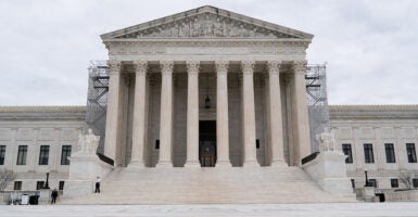 The Supreme Court building in the U.S. with classical pillars and scaffolding on either side of the entryway