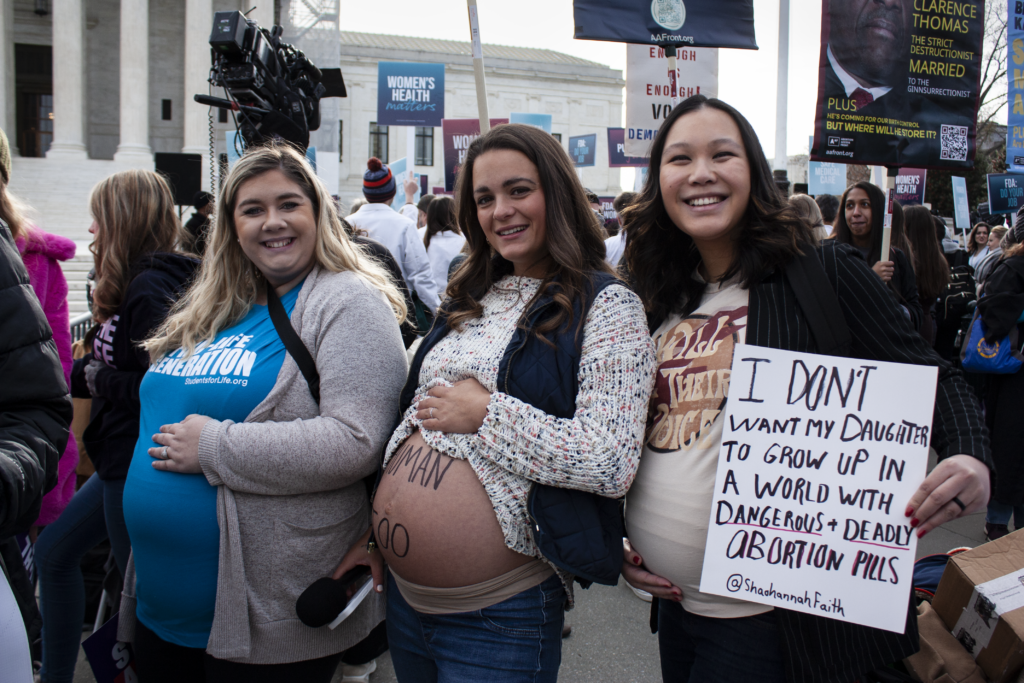 Activists rally in front of the Supreme Court building while the case's oral arguments occur inside. (Photo by Noah Slayter/The Daily Signal)