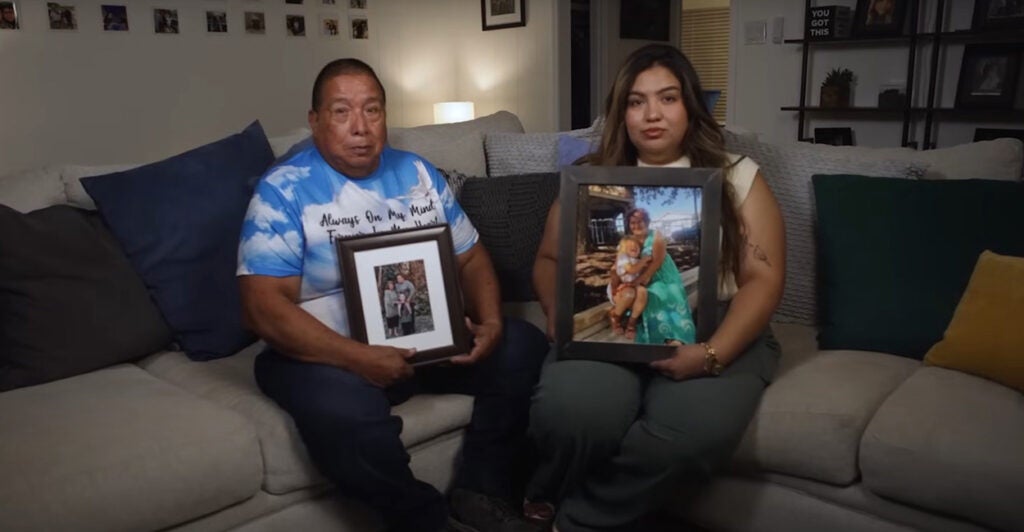 Emilio Tambunga and his daughter Elisa Tambunga sit on a couch holding pictures of their family members killed in a car crash with a human smuggler.