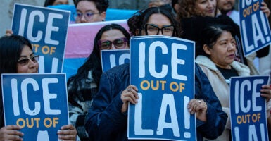 A group of activist Protesters holding up signs saying "ICE out of LA"