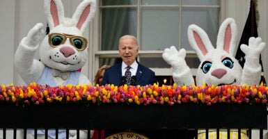 Joe Bien speaks in a suit with bunnies on his right and left