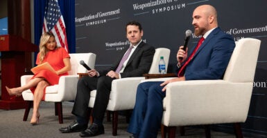 Kara Frederick in a red dress, Benjamin Weingarten in a black suit, and Michael Benz in a blue suit