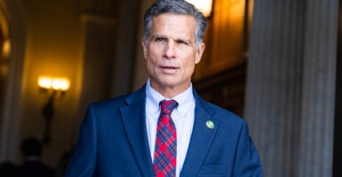 Rep. Dan Meuser is seen walking out a door in a suit.