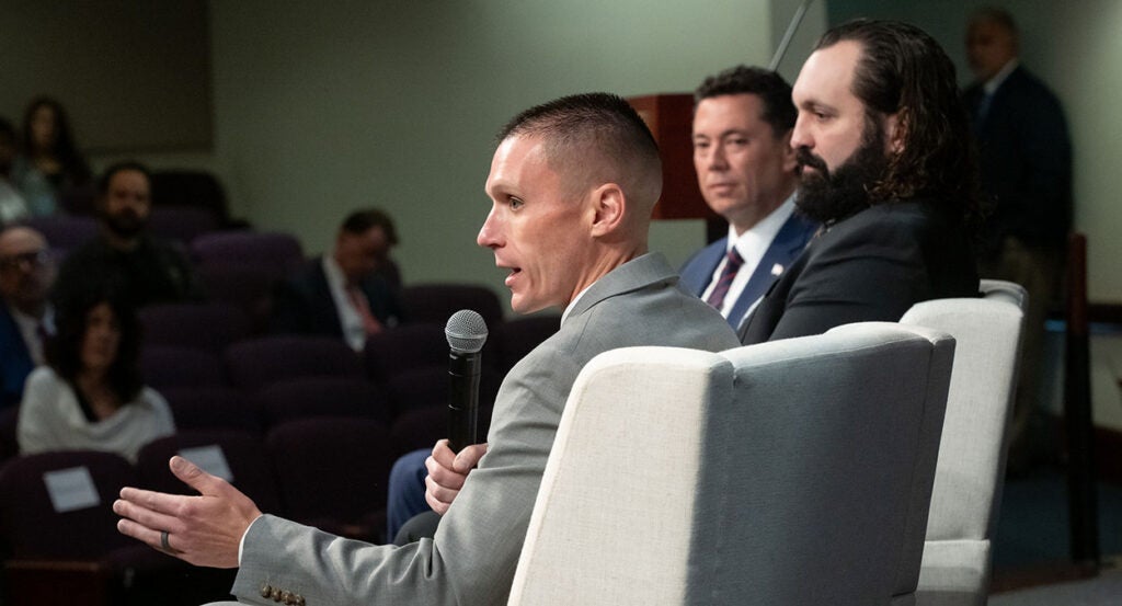 FBI agents Stephen Friend and Garret O'Boyle speak with Rep. Jason Chaffetz, wearing suits