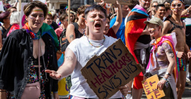 Protesters march, carying a sign reading, 