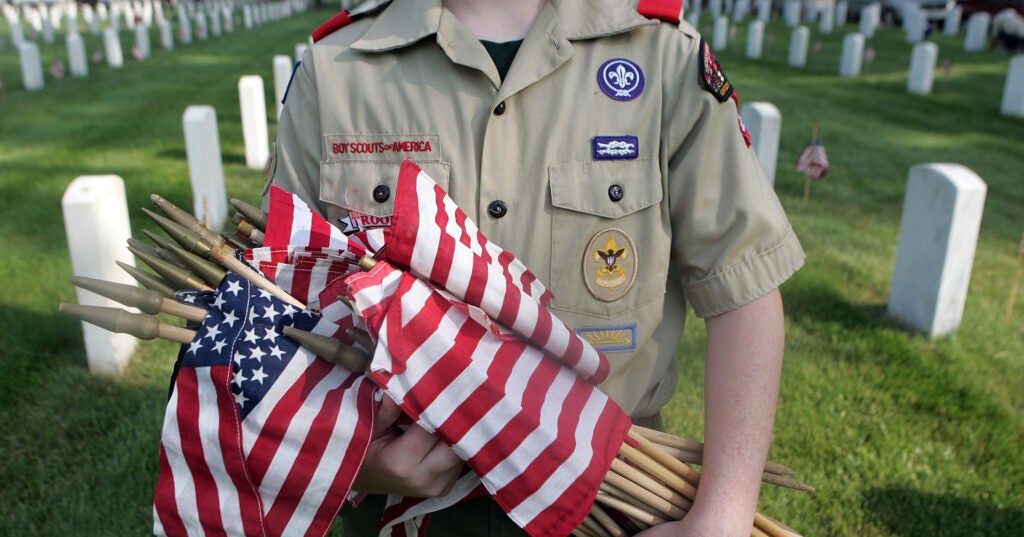 A Boy Scout holds flags to be placed on each grave at Zachary Taylor National Cemetery May 26, 2007 in Louisville, Kentucky.