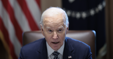 President Joe Biden sitting at a desk with a U.S. flag behind him