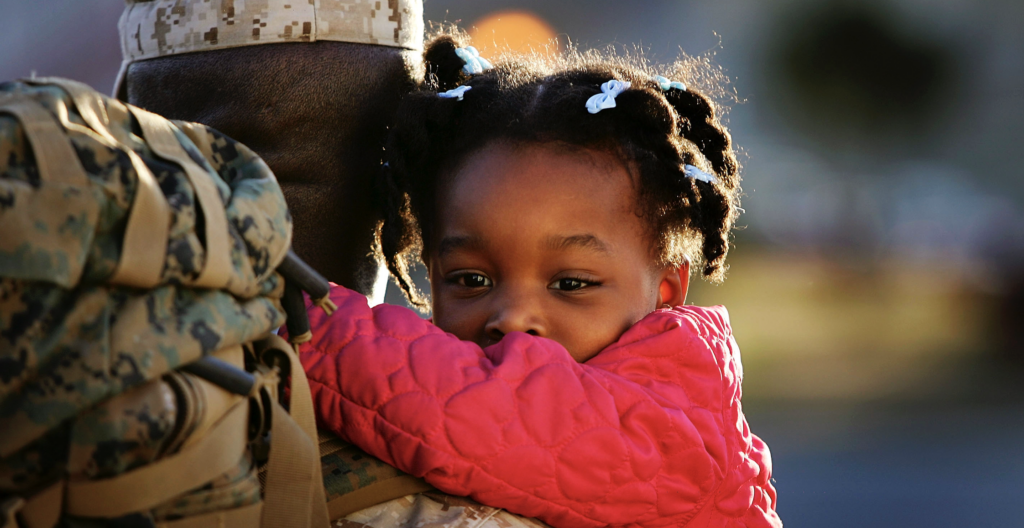 Three-year-old Gabrielle holds tight to her father Gunnery Sgt. Godfrey Marille as Marines and sailors of the 1st Marine Logistics Group (MLG) return home from a twelve-month deployment to Iraq on February 2, 2006 at Camp Pendleton, California. (Photo: David McNew/Getty Images)