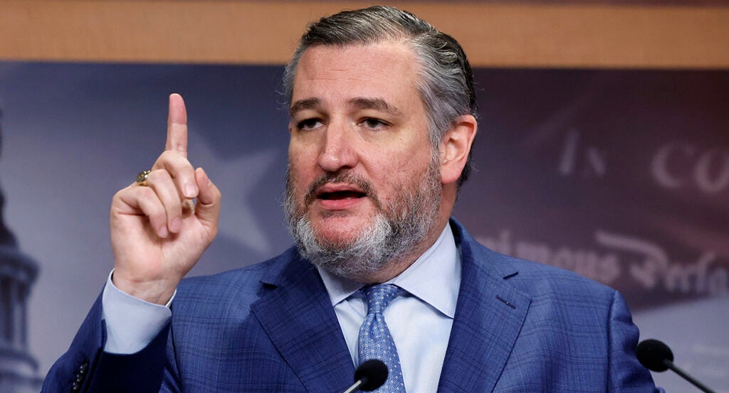 Ted Cruz raises his finger in a blue suit