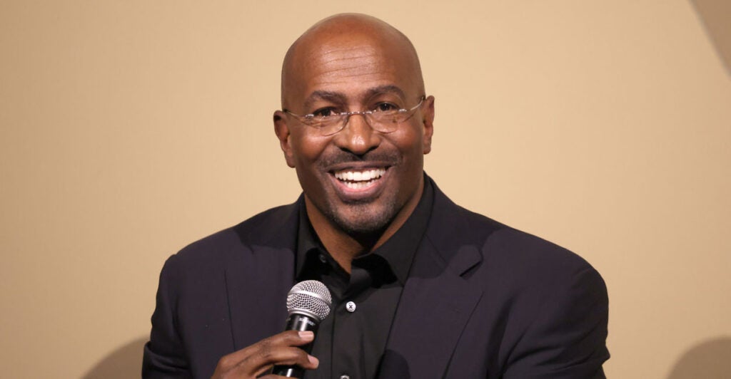 CNN host Van Jones smiling and holding a microphone.