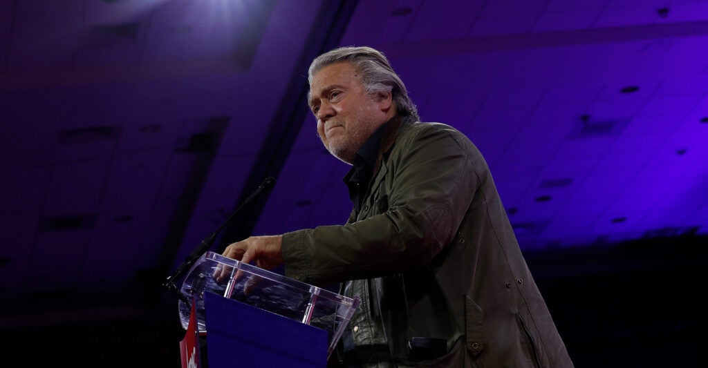 Steve Bannon giving a speech at a podium.