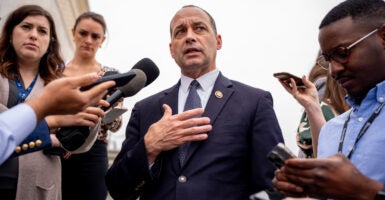 Rep. Bob Good In a suit standing in a group of reporters with microphones