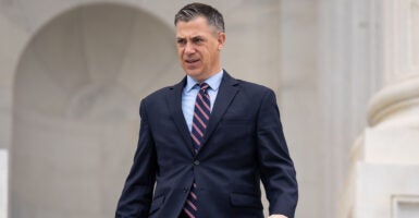 Jim banks in a suit walks on the Capitol steps