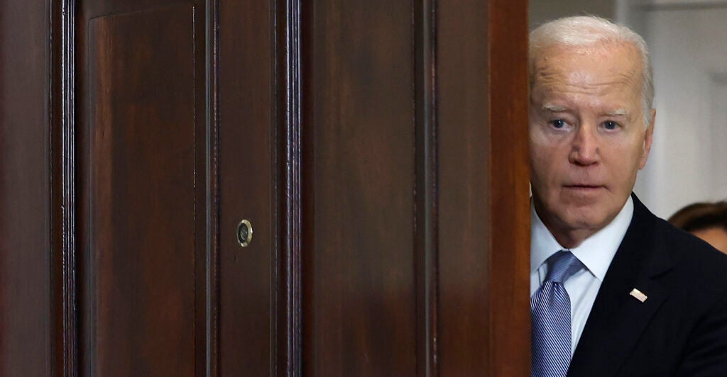 Joe Biden peeks out a door.