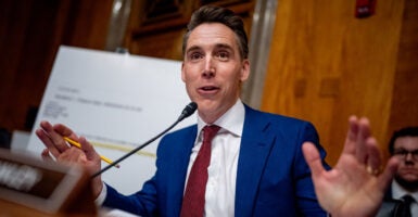 Senator Josh Hawley speaking into a microphone behind a desk.