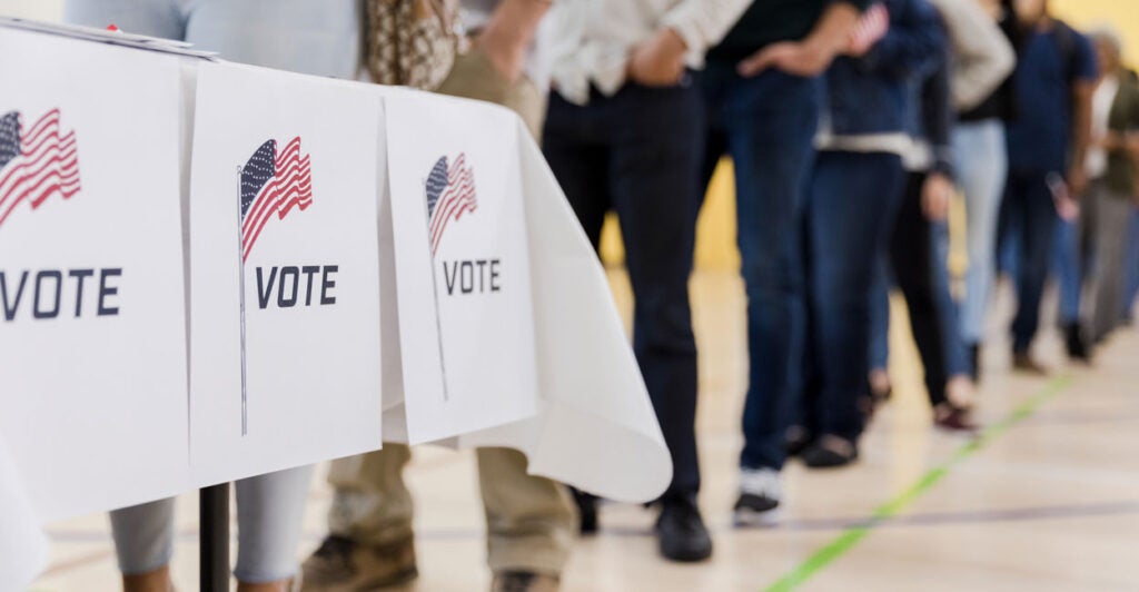 People waiting in line at voting booths.