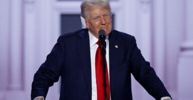 Trump speaks on stage at the Republican National Convention in a red tie and dark blue suit.