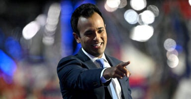 Vivek Ramaswamy in a suit points from the RNC stage