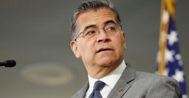 Xavier Becerra in a grey suit looks to the right