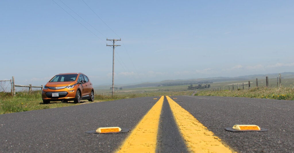 electric vehicle stranded by the side of a country road in the middle of nowhere