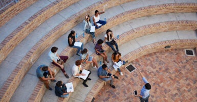 Students sit in class outside.