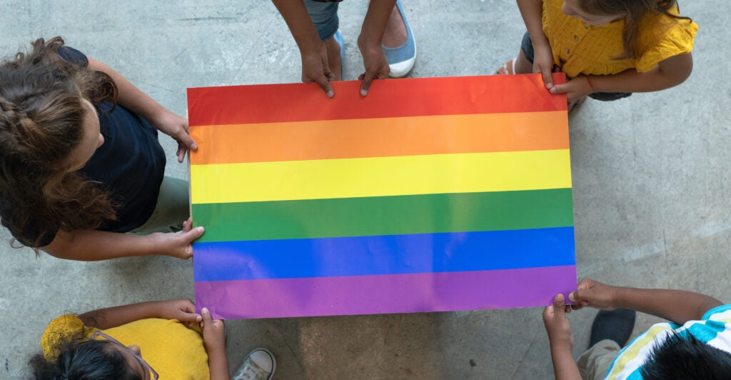 Students hold an LGBTQ flag.