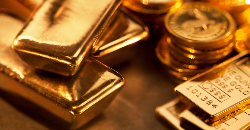 Close up image of assorted gold ingots and gold coins