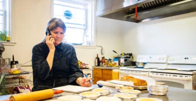 A female small business owner dealing with issues in the kitchen of her restaurant.