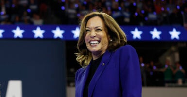 Kamala Harris in a dark blue suit speaks at a campaign rally.