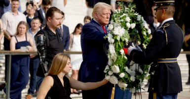 Donald Trump lays a wreath with two disabled veterans at the Tomb of the Unknown Soldier.