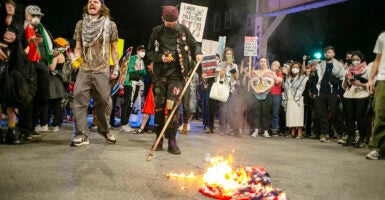 Anti-Israel protesters burn an American flag outside the DNC.