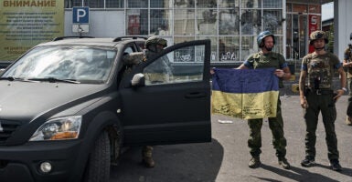 Ukrainian soldiers in Russia holding up the Ukrainian flag