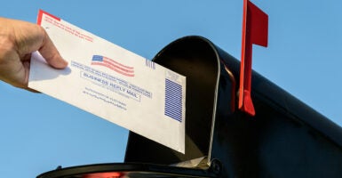 Voter places ballot in mailbox